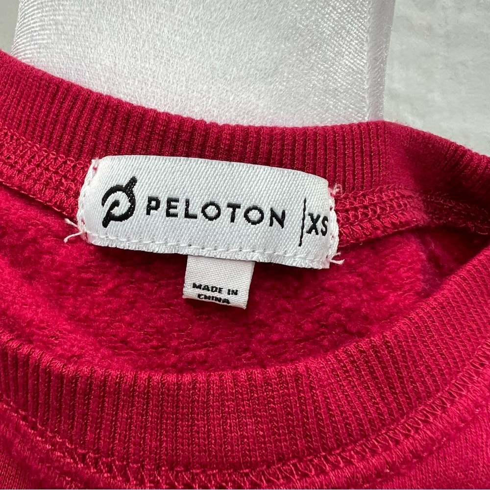 Peloton cranberry colored lightweight sweatshirt with multi-color brand name. - Picture 6 of 8